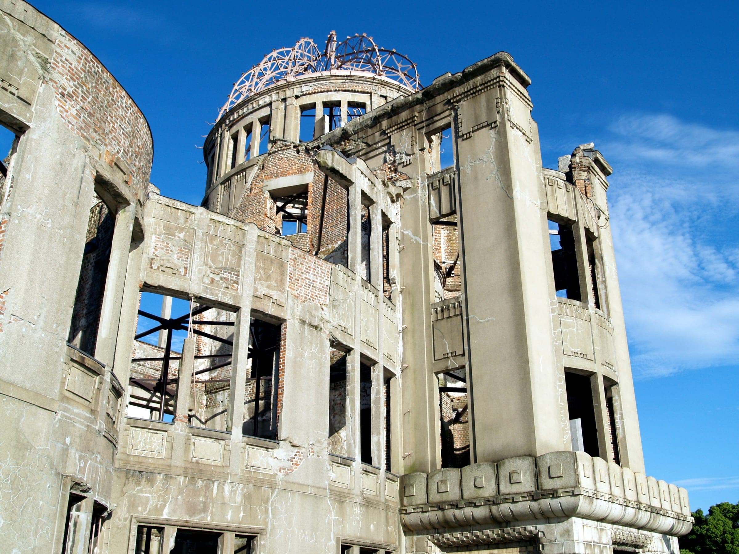 The Hiroshima Peace Memorial, its ruined walls and bare dome frame against a blue sky.